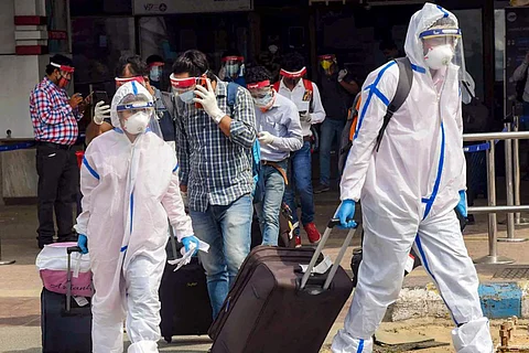 Passengers in PPE kits leaving an aiport amid the coronavirus pandemic in India