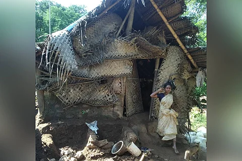 A young woman walking out of her dilapidated hut