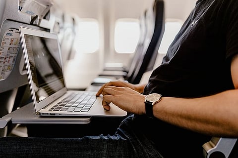 A man using a laptop on a flight