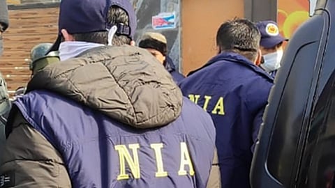 An officer wearing an a jacket with NIA written on the back