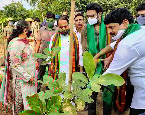 Prabhas along with other forest officials are seen in watering a sapling in Telangana