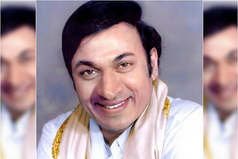 Late Sandalwood star Dr. Rajkumar is seen wearing a white shirt and shawl in the image.