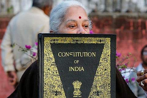 Woman holding copy of Indian Constitution/PTI File