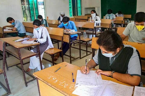 Students writing exam wearing a mask