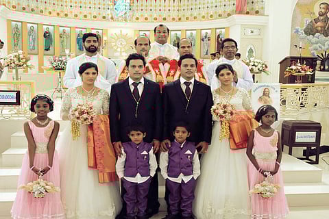 Twin priests conduct wedding of twin grooms with twin brides, with twin pageboys and flower girls