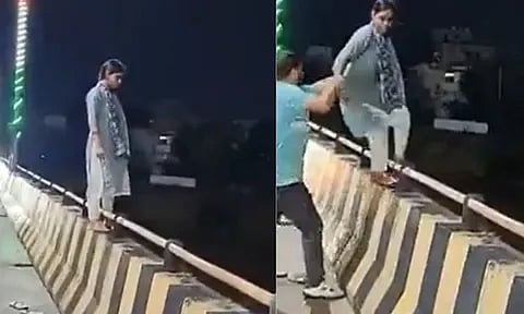 Woman climbs onto bridge