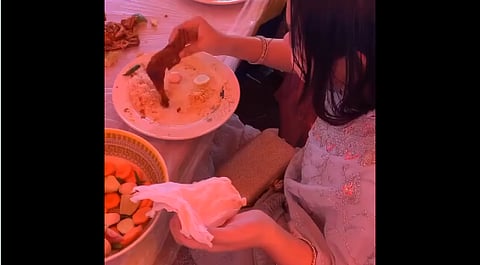 woman wrapping a chicken leg in tissue paper