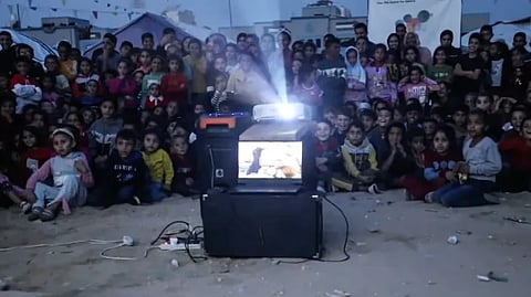 രക്തച്ചൊരിച്ചിലിനിടയിൽ സന്തോഷത്തിന്റെ നിമിഷങ്ങൾ; ഗസ്സയിൽ കുട്ടികൾക്കായി താൽക്കാലിക സിനിമാ പ്രദർശനങ്ങൾ ഒരുക്കി, ദുരന്തമുഖത്തെ കുട്ടികളിൽ പ്രതീക്ഷയും ഭാവനയും നിലനിർത്താൻ സന്നദ്ധപ്രവർത്തകർ | Cinema Screenings in Gaza City