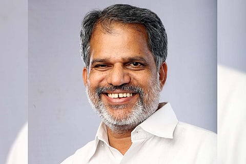 A Vijayaraghavan looking forward to the camera with a smile. He is wearing a white shirt