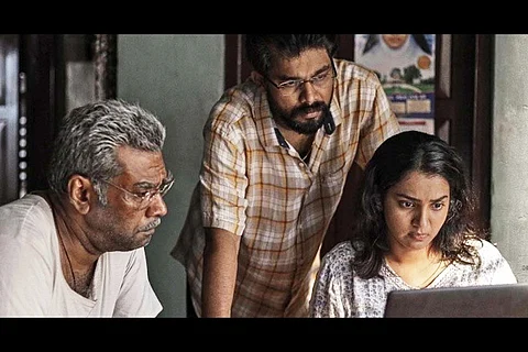 Parvathy is seen using the laptop along with Biju Menon and Sanu John Varughese.