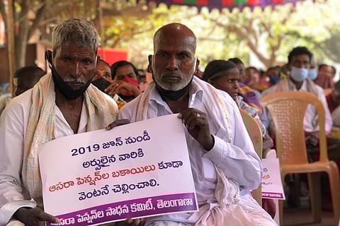 Two old aged men holding up a poster during the protest in Hyderabad