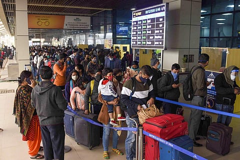 Passengers stand in queues as they wait for their turn to board flights at Patna airport