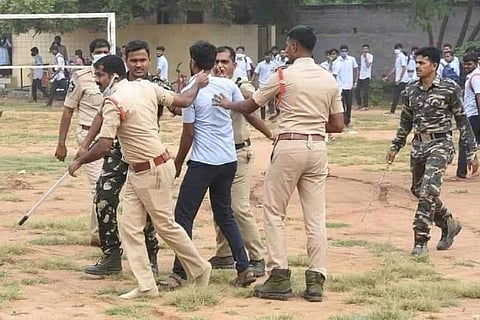 Police personnel surrounding up a student who was protesting in an Andhra college