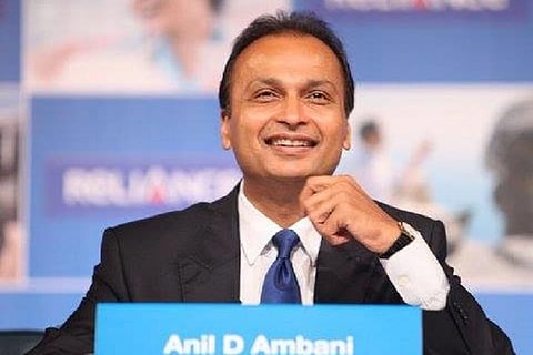 Anil Ambani smiling in a black suit