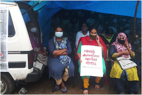Anupama, mother of Kerala missing child, in protest, flanked by some other women, in protest during rains