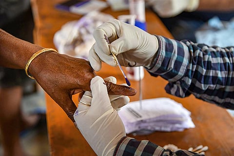 Woman getting indelible ink on her finger after voting