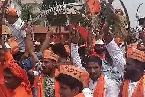 Bajrang Dal members dancing in a procession with swords