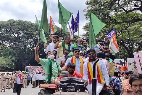 Farm leader Kodihalli Chandrashekhar arriving to Mysuru Bank Circle in a tractor