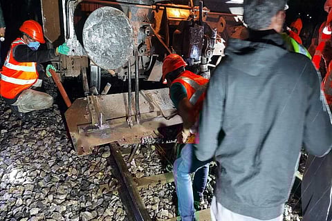 Workers repairing the damages caused in the collision between the train and truck