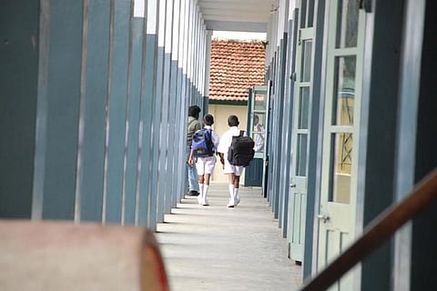 Two students walking down a school corridor