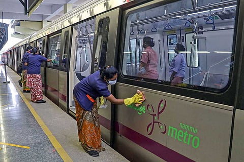 Workers cleaning a Bengaluru metro train: Bengaluru metro revises timings after Karnataka lifts weekend curfew