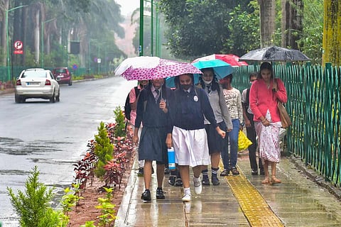 Bangalore rain file image: Students use umbrellas to protect themselves from rain, in Bengaluru