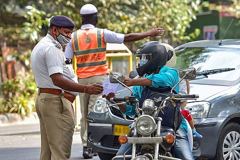 A traffic police official stopping a motorist on the road