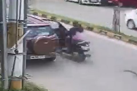 Screengrab of the woman rider hitting an open car door, before being run over