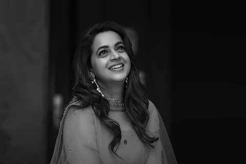 Actor Bhavana in black and white photo looking up and smiling