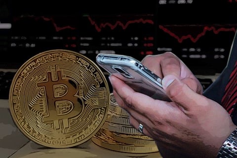 A representative image showing the bitcoin logo in the background and a person on the phone in the foreground