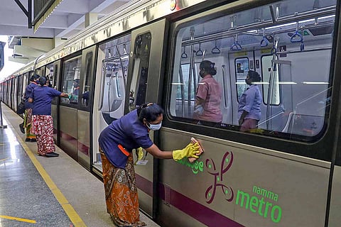 Sanitary staff disinfect the Bengaluru metro train at a station