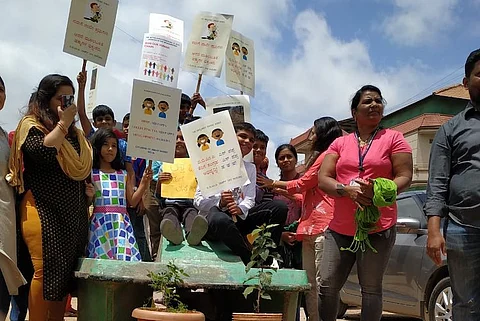 Bengaluru residents stand in boat to protest against bad roads