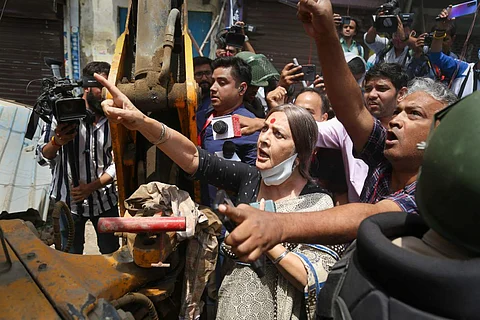 CPIM leader Brinda Karat standing in front of a bulldozer during demolition drive in Delhi's Jahangirpuri despite Supreme Court order stalling it