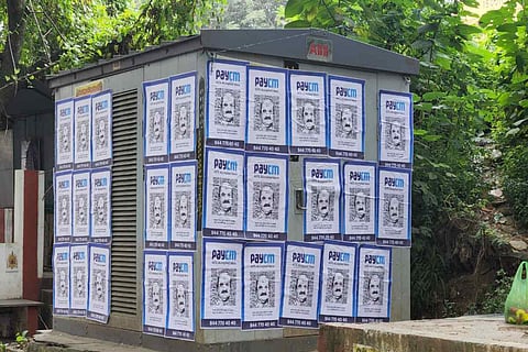 Posters of Chief Minister Bommai pasted on a transformer on the pavement.