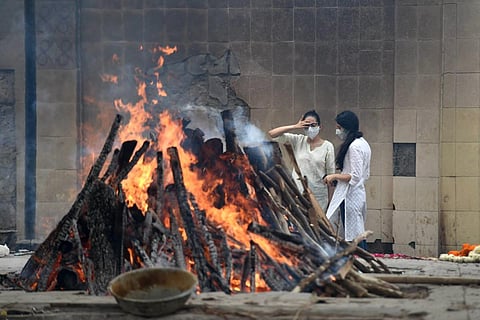 Family members react at the cremation of a COVID-19 victim, during the second wave of coronavirus, in New Delhi, Tuesday, May 18, 2021.