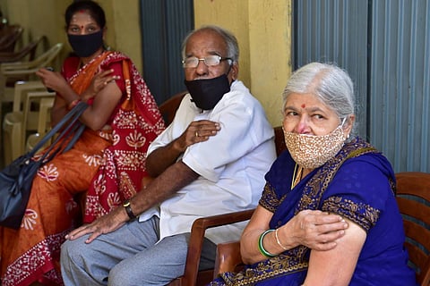 Beneficiaries wait at an observation room after receiving a dose of COVID-19 vaccine at a vaccination centre