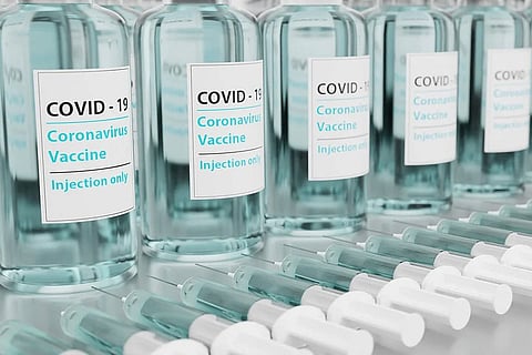 Vials of COVID-19 vaccines with syringes at the bottom