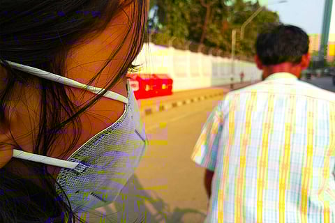 Child and man walk wearing a mask on the road