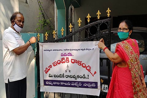Residents placing flex banner with COVID-19 caution on their gate