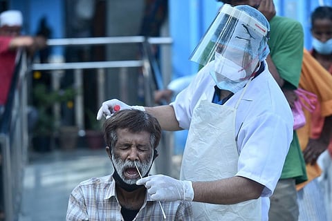 A health worker collects swab sample from a person for COVID-19 test,