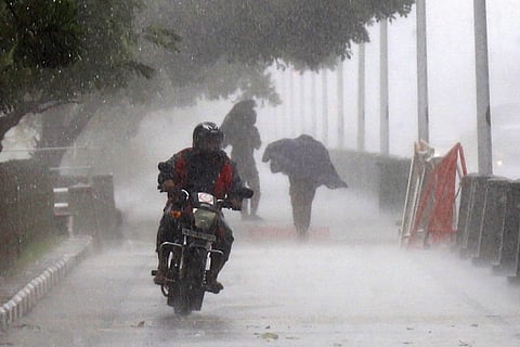 A man riding a bike amid heavy rains.