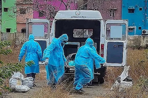 Medical professionals carrying corpse of a person who died of COVID-19