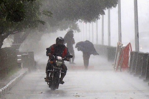 A man rides a bike in heavy rain