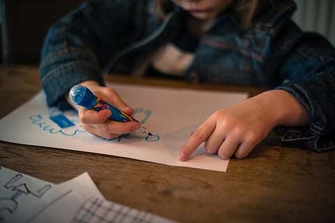 Child drawing in a book