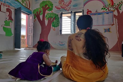 A girl child with her mother at a government run childcare center in Telangana