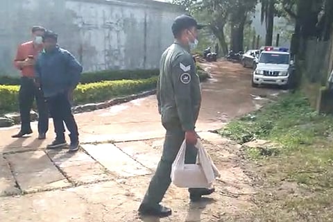 An IAF officer carrying a cloth package containing the black box