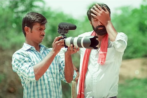 A man is seen learning how to use a camera, while another man is expressing disbelief through a facepalm.