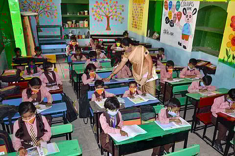Students wearing masks attend a class after schools resumed for the students of classes 1st to 5th in Mirzapur