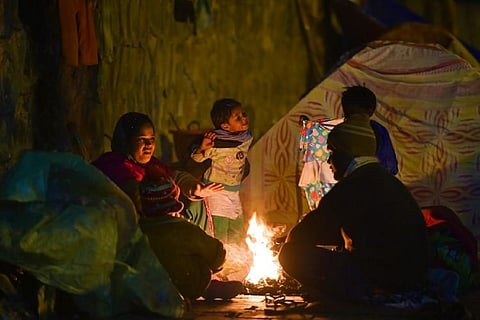 People sitting around a bonfire to keep warm