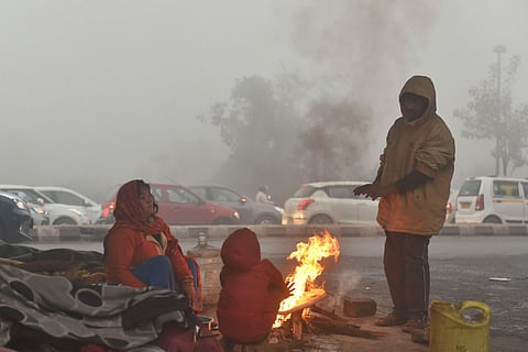 A group of people gathered around a fire for warmth amid a cold wave in India